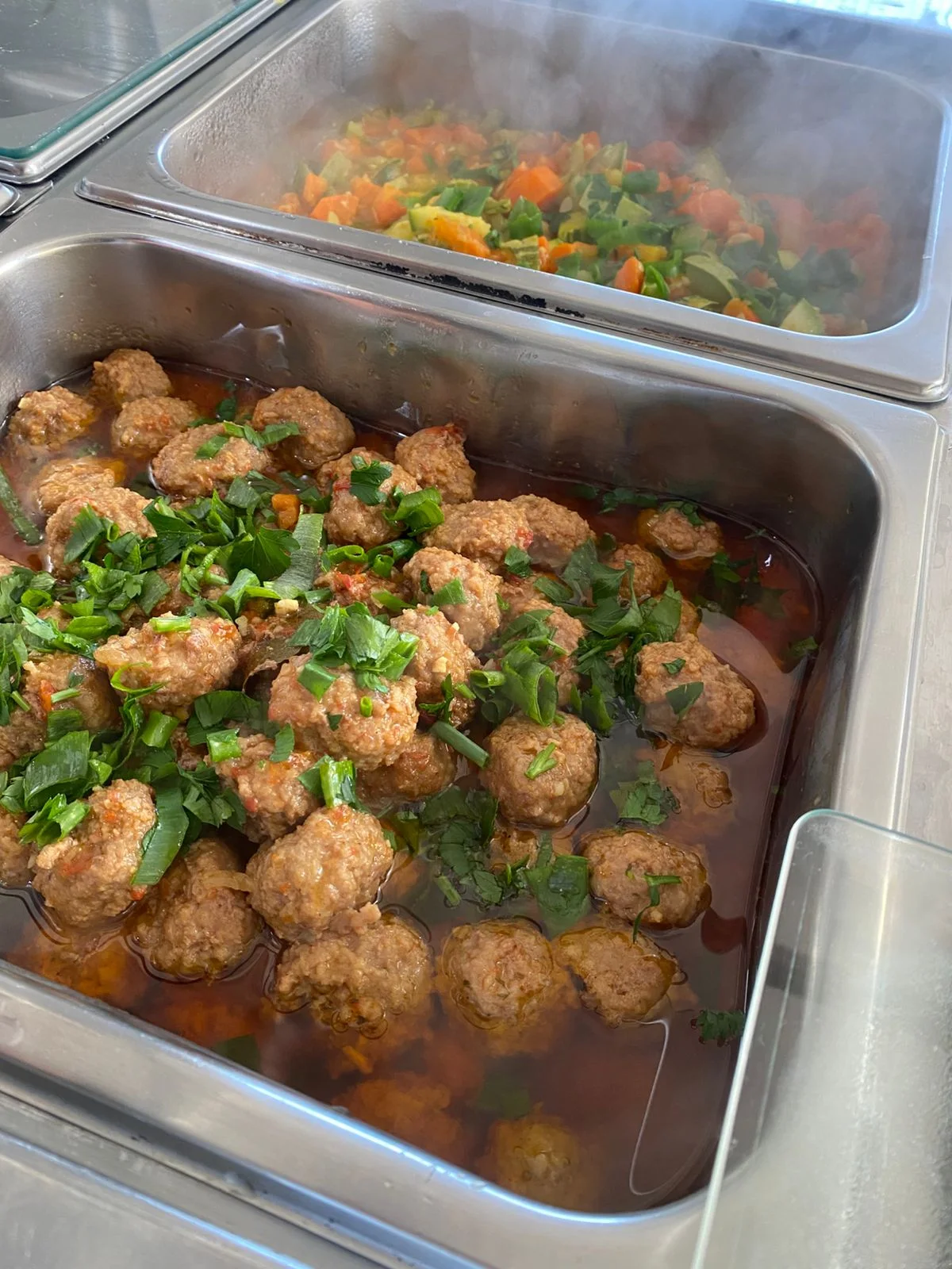 Almôndegas ao molho e legumes quentes no buffet